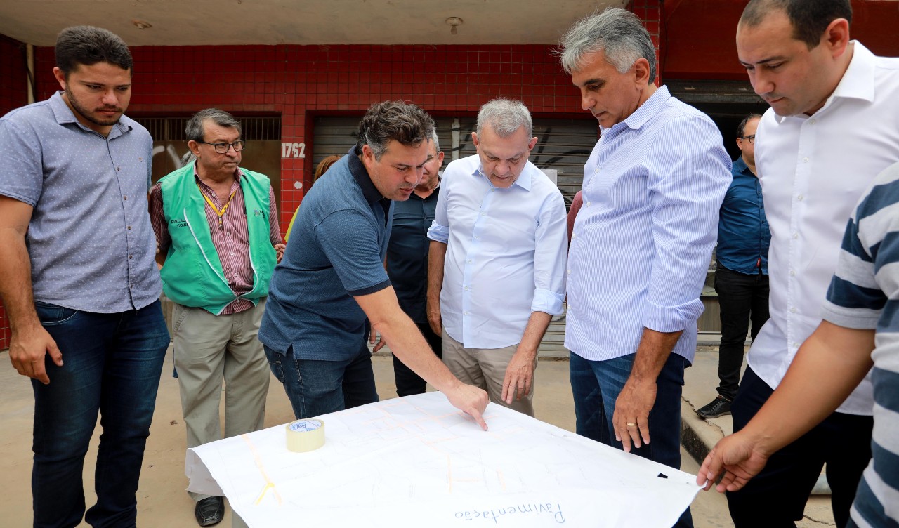 prefeito observa a planta das obras